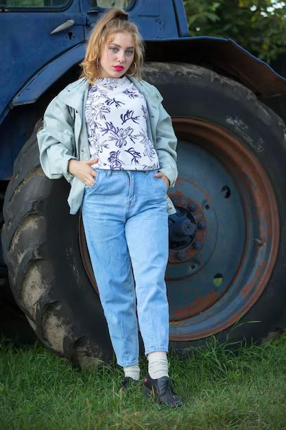 Девушка у большого колеса трактора